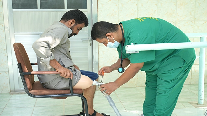 أحد الفنيين يقوم بمعايرة وتركيب الطرف الصناعي